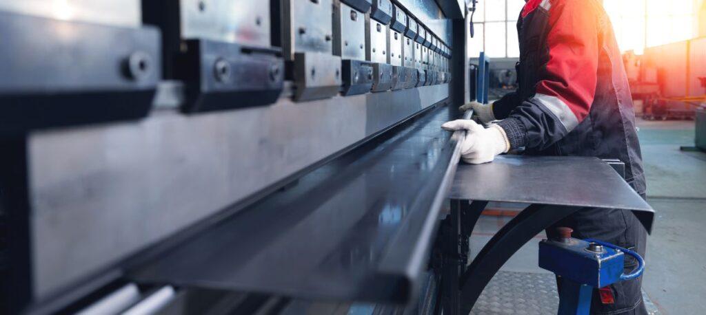 Metallverarbeitung mit CNC-Technik bei Schlosserei Freiburg: präzises Abkanten von Stahlblech durch Fachpersonal.
