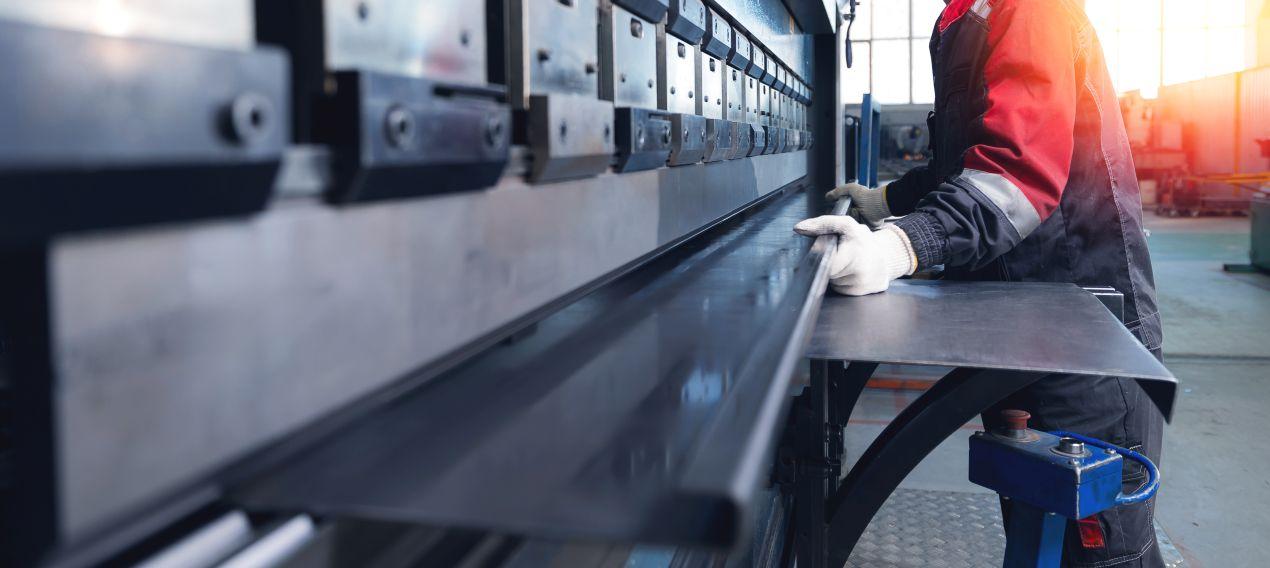 Metallverarbeitung mit CNC-Technik bei Schlosserei Freiburg: präzises Abkanten von Stahlblech durch Fachpersonal.